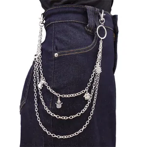Detail of silver layered waist chain with snowman, snowflake and gift pendants on denim