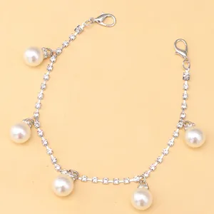 Close-up of sparkling rhinestone shoe chain with five elegant pearl pendants and clasps