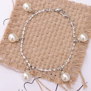 Macro detail of silver shoe chain with sparkling rhinestones and white pearls on burlap