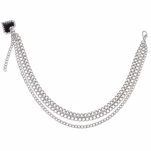Detail view of multi-layered silver metal shoe chain with black mosaic heart charm