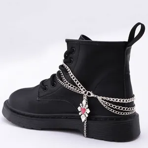 Bottes de combat noires style hip hop avec chaînes argentées et pendentif croix cœur rouge