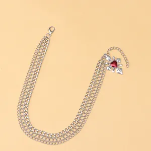 Détail d'une chaîne de chaussure argentée à trois couches avec pendentif cœur rubis