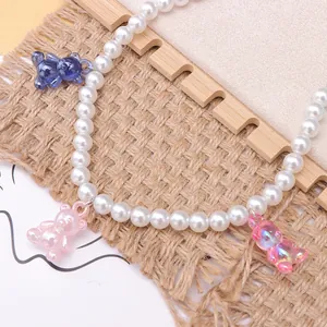 Detailed shot of pastel resin bear charms on a white imitation pearl shoe charm chain