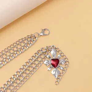 Vue détaillée de la chaîne triple couche en métal argenté avec pendentif croix cœur rouge