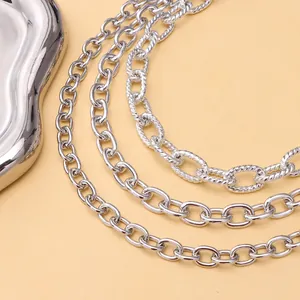 Dettaglio di catene metalliche argentate a strati con maglie ovali e trama a corda