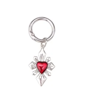 Detail eines gotischen Schuhanhängers aus Silber mit rotem Herz und Metall-Federring