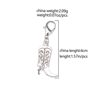 Detail of silver cowboy boot pendant with floral patterns and lobster clasp closure