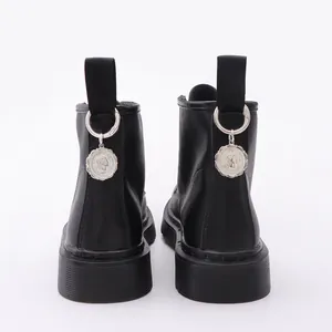 Schwarze matte Lederstiefel mit Gothic-Metallanhängern und Porträt-Reliefs am Absatz