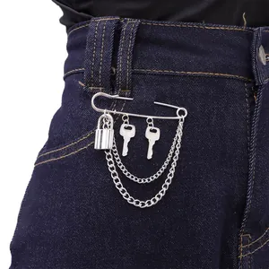 Detail of silver safety pin brooch with hanging lock, keys and double metal chains