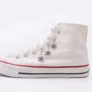 Detail view of hexagram charms with crown relief and lobster clasps on canvas shoes
