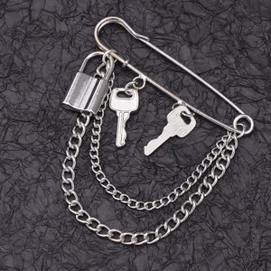 Detailed close-up of a silver punk brooch with padlock, keys, and layered metal chains
