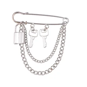 Punk silver safety pin brooch featuring a lock, two keys, and layered metal chains
