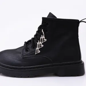 Detail of silver heart-shaped charms and metal eyelets on black leather Martin boots