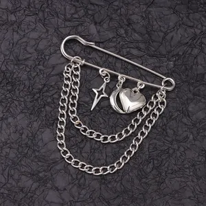 Detailed close-up of silver safety pin brooch with star, moon, heart charms and dual chains