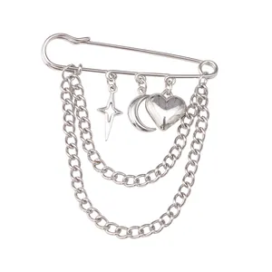 Silver pin brooch with triple chains and star, moon, and heart charms on white background