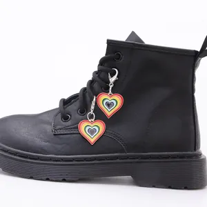 Detalle macro de colgantes de corazón arcoíris con cierre de langosta en botas negras