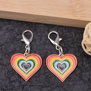 Colgantes de corazón en esmalte arcoíris con cierres de langosta plateados sobre negro