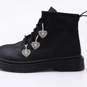 Silver hollow heart butterfly charms with lobster clasps attached to black martin boots