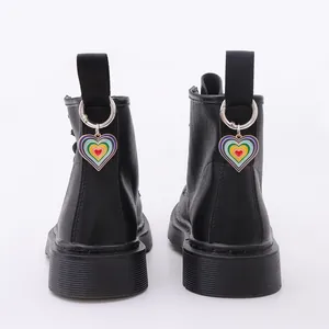 Vista posterior de botas de cuero negro con dijes de corazón arcoíris en el talón