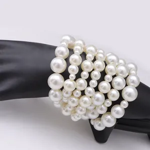 Bracciale multistrato con perle artificiali bianche su espositore a mano nera chic
