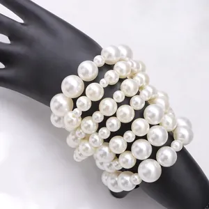 Dettaglio del set di braccialetti di perle bianche multistrato su un modello di mano
