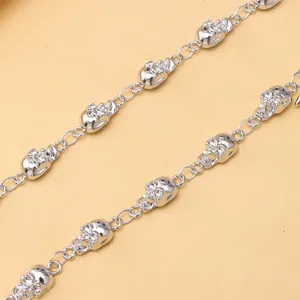 Detailopname van de zilveren punk broekketting met gepolijste metalen schedels