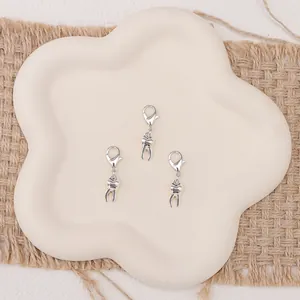 Detalle macro de tres colgantes de dientes plateados con corazones en una bandeja