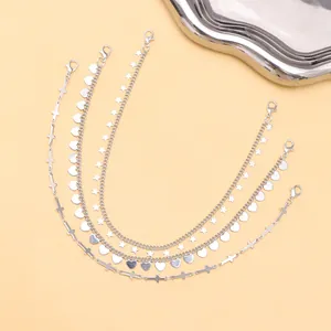 5-piece silver accessory set with heart, star and cross pendants on soft yellow backdrop