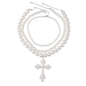 Set di collane di perle a tre strati con grande ciondolo a croce decorativo su bianco
