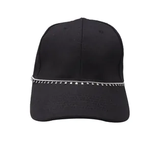 Detail of silver star chain accessory on a black baseball cap with punk style charms