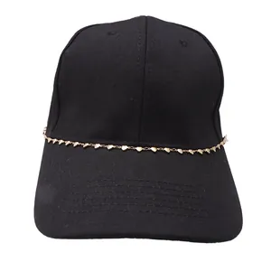 Détail de la chaîne dorée en forme de cœur sur une casquette de baseball noire en coton