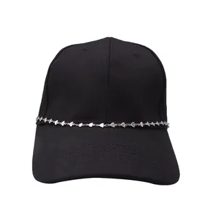 Close-up of a silver heart-shaped metal chain on a black baseball cap detail