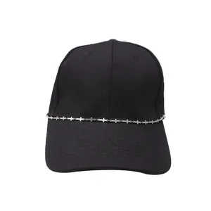 Detail of silver cross chain on a black cotton baseball cap with street style design