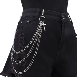 Detail einer mehrlagigen silbernen Hosenkette mit Kreuzanhänger an schwarzer Jeans
