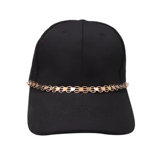 Close-up of black baseball cap featuring a decorative gold metal chain on the brim