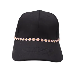 Vue détaillée d'une chaîne de strass marguerite rose sur une casquette noire