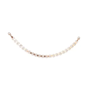 Detail of rose gold chain accessory with dual lobster clasps and polished round metal discs