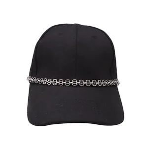 Detail of silver double chain accessory on black twill baseball cap in punk style