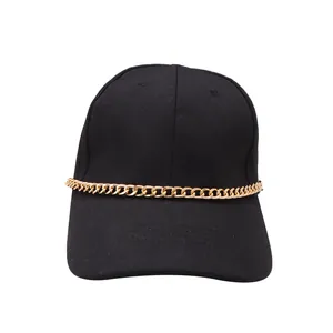 Detail showing a black baseball cap featuring a golden metal chain across the brim and crown