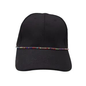 Detail of a black baseball cap with vibrant rainbow rhinestones along the crown base