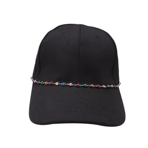 Close-up of black baseball cap featuring a metal chain with colorful heart charms