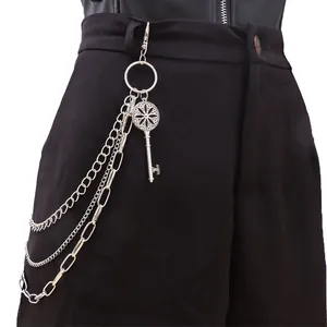 Detail einer mehrlagigen silbernen Hosenkette mit Vintage-Schlüsselanhänger auf schwarzer Hose