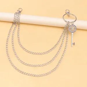 Detail einer mehrlagigen silbernen Hosekette mit Vintage-Schlüsselanhänger und Karabinern