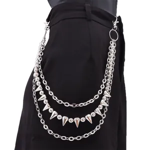 Close-up of triple-layered silver punk waist chain with metal beads and spikes on black pants