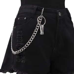 Close-up of a punk silver metal waist chain with ring pendant on black denim shorts