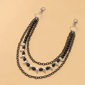 Close-up of triple-layered black pants chain with silver spikes and beaded details