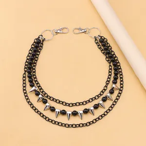 Close-up of triple-layer punk pants chain with black beads and silver metal spikes