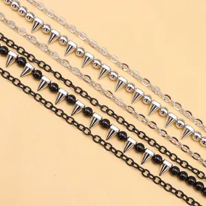 Detail of punk style pant chains featuring silver and black beads with cone pendants