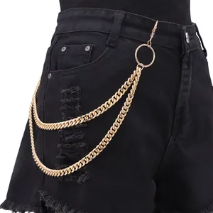 Detail of double-layered gold pants chain with metal ring styled on black denim shorts