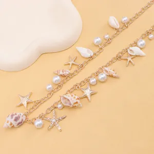 Detail of gold beach waist chain with seashells, starfish pendants and white pearls